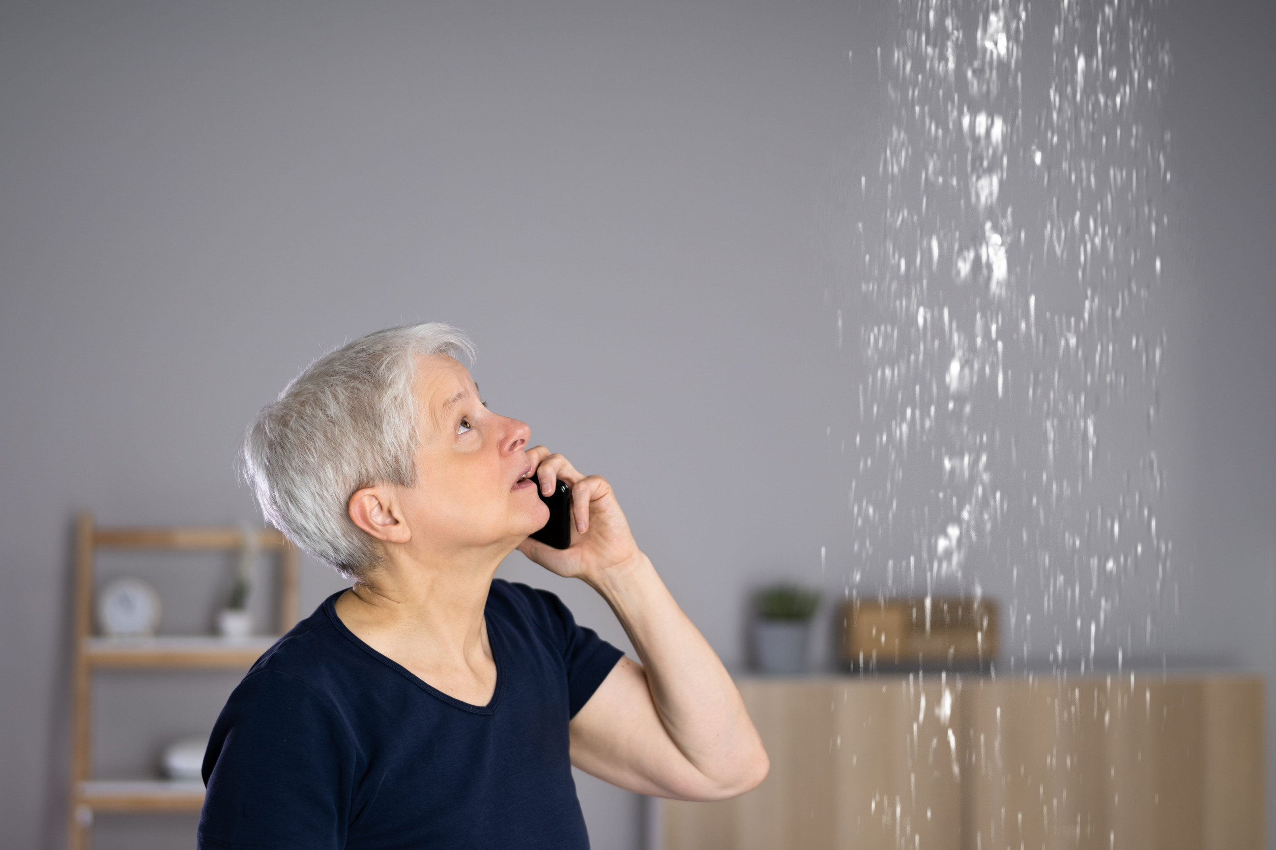 Worried Woman Calling Plumber To Fix Burst Pipe - Tap Tap Plumbing North West