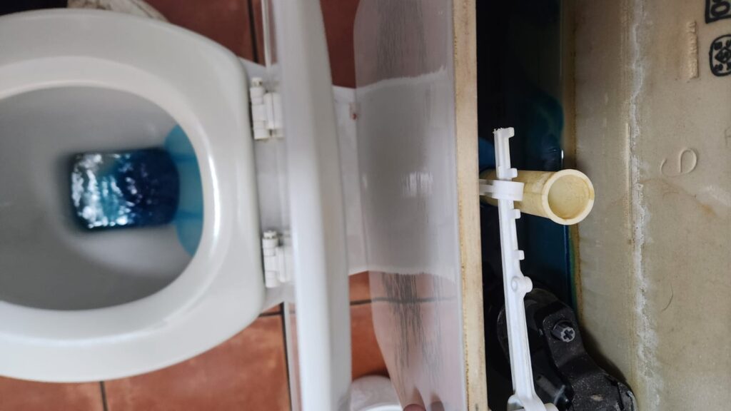 Blue food colouring visible in a toilet bowl after a toilet leak test, confirming a leaking flush valve causing a continuously running toilet.