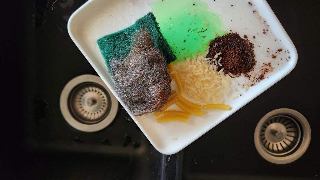 Common household items like grease, coffee grounds, rice, pasta and food debris that can contribute to a blocked kitchen sink drain.